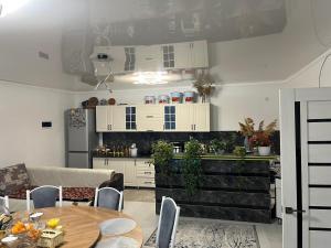 a kitchen with white cabinets and a table at Friendly House in Bokonbayevo