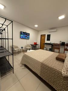 a bedroom with a bed and a flat screen tv at Condomínio Feitosa Barros II in Maceió