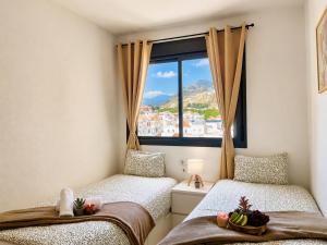 two beds in a room with a window at Horizon Santa Monica in Aguadulce