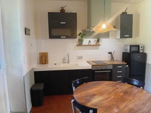 a kitchen with a wooden table and a sink at Le Tilleul du Perche - Jardin clos - Fibre - Télétravail - Parking privé in La Ventrouze