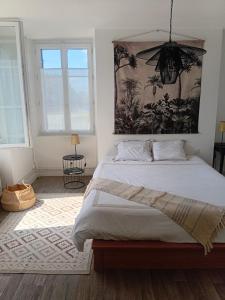a bedroom with a large bed and two windows at Le Tilleul du Perche - Jardin clos - Fibre - Télétravail - Parking privé in La Ventrouze