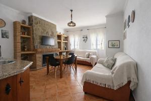 a living room with a couch and a table with chairs at Los Meri in Grazalema