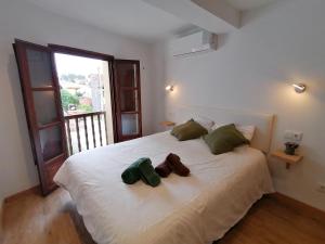 a bedroom with a white bed with two stuffed animals on it at Apartamentos Almenada in Llanes