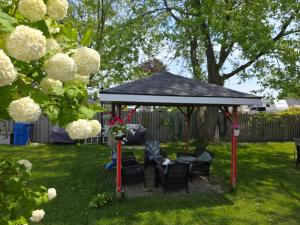 a gazebo with chairs and a table in a yard at Lakeview Motel & Cottage in Kincardine