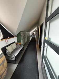 a long hallway with a couch and a window at Megacentrum Szállás in Szekszárd