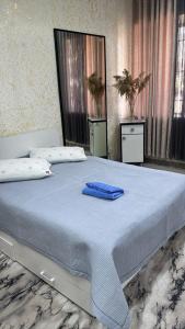 a bedroom with a large bed with blue towels on it at Friendly House in Bokonbayevo +8 photos
