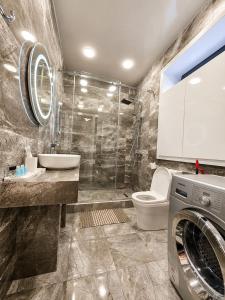 a bathroom with a toilet and a sink and a washing machine at Villa Arsha in Arsha +20 photos