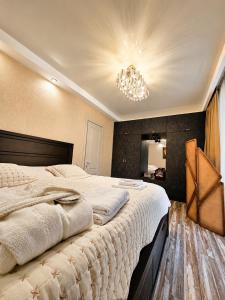 a bedroom with a large bed with a chandelier at Villa Arsha in Arsha