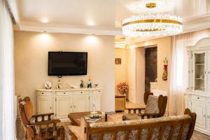a living room with a table and a television on a wall at Villa Arsha in Arsha
