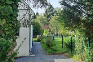 a garden with a fence and a path at Le Cozy Cocon in Franqueville-Saint-Pierre