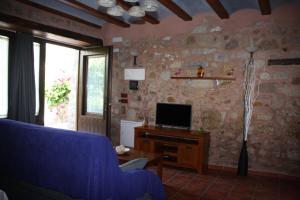 a living room with a blue couch and a tv at Apartamentos Rio Mora in Mora de Rubielos