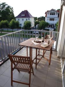 a wooden table and two chairs on a balcony at Strandstraße by Rujana in Baabe