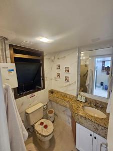 a bathroom with a sink and a toilet and a mirror at Apartamento completo Premium-Frente ao Mar Wi-Fi rápido-ar-condicionado in Rio de Janeiro +61 photos