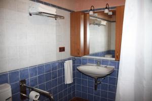 a blue tiled bathroom with a sink and a mirror at Apartamentos Rio Mora in Mora de Rubielos