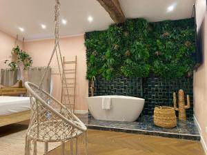 a bathroom with a tub and a green wall at Mas Beauregard in Anduze
