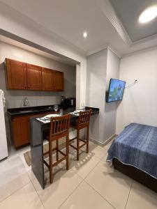 a kitchen with a table and two chairs and a bed at Condomínio Feitosa Barros II in Maceió