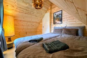 a bedroom with a large bed in a log cabin at The Perfect Stop - Northern Halo in Lødingen