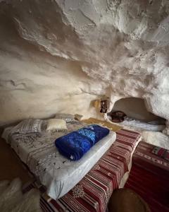 a bedroom with a bed in a stone cave at Dar Sana in Qaşr al Ḩallūf