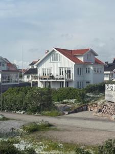 a large white house with a red roof at Fisketången Seaside Stay in Kungshamn