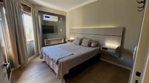 a bedroom with a large bed and a television at Vcp urban suites in Villa Carlos Paz +11 photos