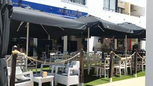 a group of tables and chairs under an umbrella at Sol Apartments in Vilamoura