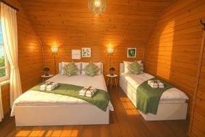 two beds in a room with wooden walls at Pensiunea Anda in Călăţele +75 photos