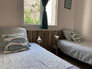 a bedroom with two beds and a window at Chez Stella in Audierne