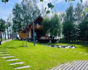 a house in the middle of a green yard at Rumelówka in Wawrowice