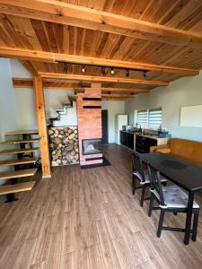 a living room with a table and chairs and a fireplace at Rumelówka in Wawrowice +4 photos