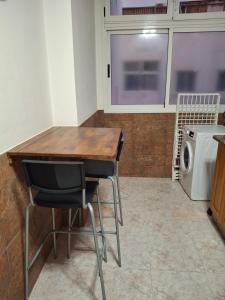 a kitchen with a table and two chairs and a washing machine at Casa Rosi in Gran Tarajal