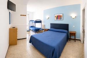 a bedroom with a blue bed and a table and chairs at L´Hostalet in Tossa de Mar
