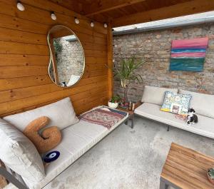 a patio with a couch and a mirror on a wall at The Nook - Balatonkiliti in Siófok +135 photos