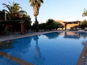 a large swimming pool with a palm tree and chairs at Cozy Stay Corfu – Studio 10 in Gouvia +33 photos