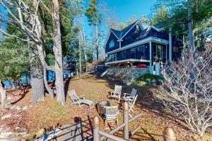 a large blue house with chairs in front of it at Rescue Lake in Ludlow