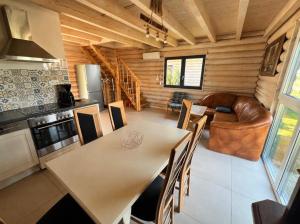 a kitchen and living room with a table and a couch at Domki letniskowe Malina 4 in Gawrony