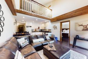 a living room with a leather couch and a table at Mountainside Retreat in Frisco
