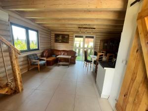 a living room with a couch and a table at Domki letniskowe Malina 4 in Gawrony