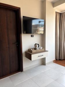 a bathroom with a sink and a television on the wall at Pyra King Royal Pyramids Hotel in Cairo