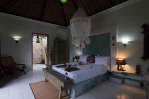 a bedroom with a large bed and a chandelier at Villa Anjing in Nusa Dua +166 photos