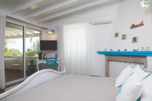 a bedroom with a bed and a living room at PALMASERA CHARMING - Rooms & Suites in Cala Gonone