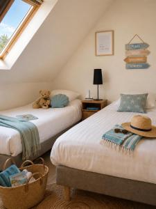 a bedroom with two beds with a teddy bear sitting on it at APPART HÔTEL MON CALME in Piriac-sur-Mer +30 photos