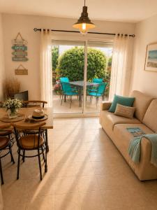 a living room with a couch and a table and chairs at APPART HÔTEL MON CALME in Piriac-sur-Mer