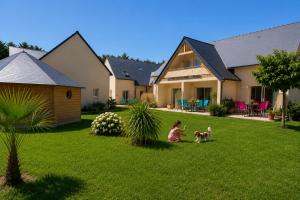 a little girl playing with a dog in a yard at APPART HÔTEL MON CALME in Piriac-sur-Mer