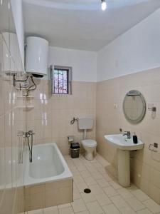 a bathroom with a tub and a toilet and a sink at Himara Holiday House in Himare +18 photos