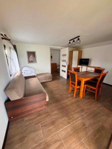 a living room with a table and a dining room at Domki letniskowe u Marty in Łeba