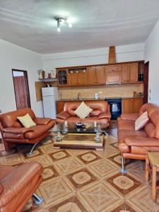 a living room with leather furniture and a coffee table at Himara Holiday House in Himare