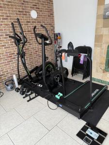 a gym with several exercise bikes and a brick wall at Tomorrowland Home in Boom