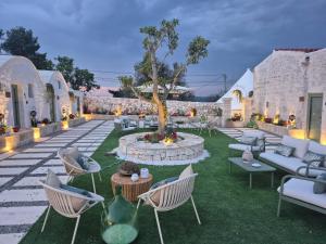 a courtyard with chairs and a tree and a fountain at Borgo Pascarosa in Ostuni