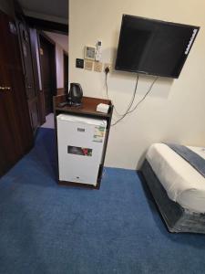 a bedroom with a bed and a television on the wall at فندق مواسم الخير in Al ‘Azīzīyah