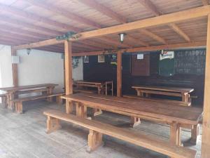 a row of wooden benches in a room with a chalkboard at Penzion Athena in Velenov